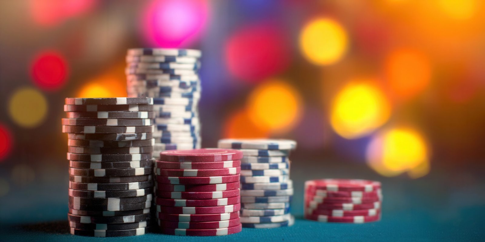 A vibrant image showcasing stacks of colorful poker chips, set against a blurred background of bokeh lights.